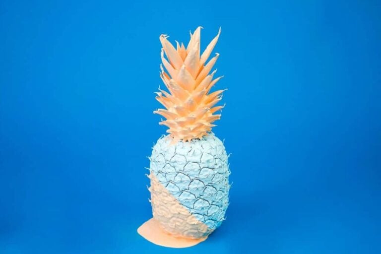Vibrant pineapple sculpture with a blue background, highlighting tropical flavors and summer vibes.